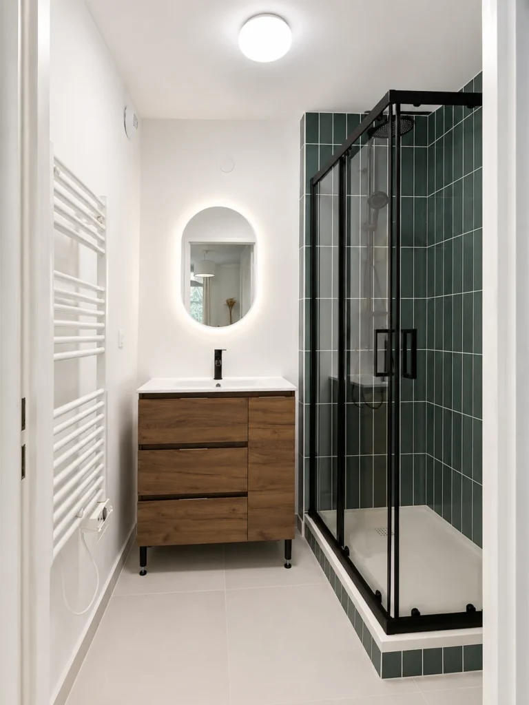 Rénovation de salle de bain avec douche, faïence verte et robinetterie noire réalisée par SERBA’NET